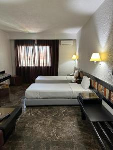 una camera d'albergo con 2 letti e una scrivania di Ourida Urban Hotel Rabat a Rabat