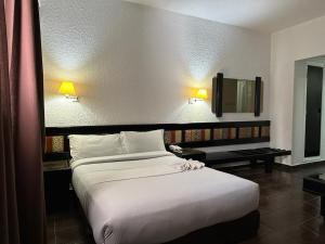 una camera con un grande letto e una TV di Ourida Urban Hotel Rabat a Rabat