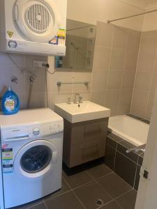 a bathroom with a washing machine and a sink at Plush 2 bedroom apartment Kingston in Kingston 