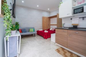 eine Küche mit einem Wohnzimmer mit einem roten Sofa in der Unterkunft Dimora D&G in Syrakus