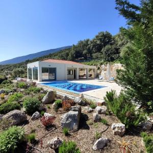uma casa com piscina no meio de um quintal em Villa Iremia Des vacances waouw en toute sérénité! em Chaliotata