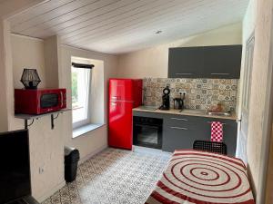 a kitchen with a red refrigerator and a stove at Douceur occitane in Saint-Chinian