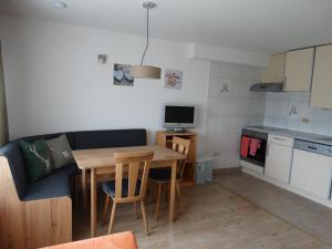 ein Wohnzimmer mit einem Tisch und einem Sofa sowie eine Küche in der Unterkunft Haus Frans Josef in Seeboden