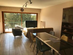 a living room with a couch and a table and chairs at gite du viaduc in Semur-en-Auxois