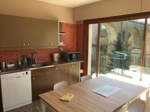 a kitchen with a table and a window with a view at gite du viaduc in Semur-en-Auxois