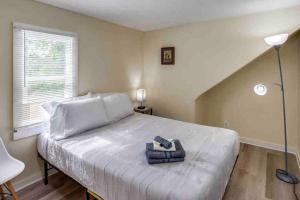 1 dormitorio con 1 cama blanca grande con lámpara en ~Cozy Home~ Steps to RIT by UofR/Airport/DWTN w/AC en Rochester