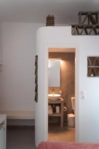 La salle de bains est pourvue d'un lavabo, de toilettes et d'un miroir. dans l'établissement Aggelikoula Rooms, à Tinos