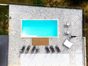 una vista aérea de una piscina con sillas y TV en Luxury Villa Rilassante-Heated Pool,Full Privacy,Children Playground, en Sinj