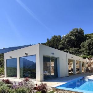 una casa blanca con piscina frente a ella en Villa Iremia Des vacances waouw en toute sérénité!, en Chaliotata