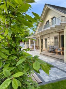 a patio of a house with a tree at Apartamenty Naturapart in Dziwnów