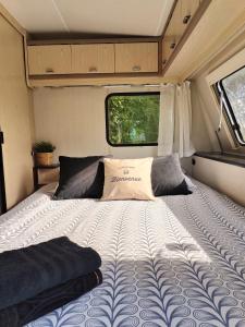 uma cama grande na parte de trás de uma caravana em La « Ravane » em Cysoing