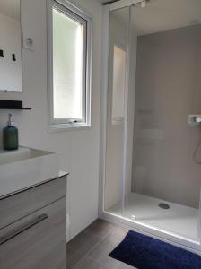 a bathroom with a shower with a glass door at Mobil Home Camping Mar Estang 4* in Canet-en-Roussillon