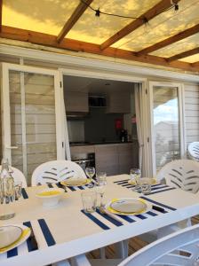 a dining room table with chairs and a white table cloth at Mobil Home Camping Mar Estang 4* in Canet-en-Roussillon