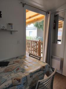 a bedroom with a bed and a balcony with a patio at Mobil Home Camping Mar Estang 4* in Canet-en-Roussillon