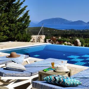 una piscina con 2 tumbonas junto a ella en Villa Iremia Des vacances waouw en toute sérénité! en Chaliotata