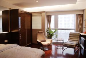 1 dormitorio con 1 cama, 1 silla y 1 ventana en Kaibin Apartment- Nanjing University Branch, en Nanjing