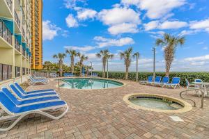 eine Terrasse mit Stühlen, einem Pool und Palmen in der Unterkunft Oceanfront 2 Bedroom Suite with Incredible Views! Carolinian 630 in Myrtle Beach