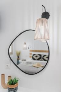 un espejo negro colgado en una pared con un dormitorio en Petros Studios & Suites en Naxos