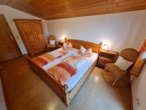 1 dormitorio con 1 cama grande y 1 silla en Lauchlehen, en Bischofswiesen