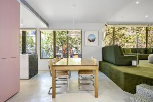 a dining room with a table and a green couch at Bourke Street Urban Retreat in Melbourne