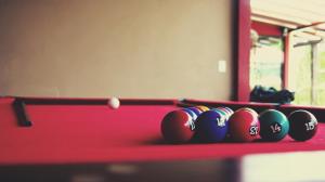 a row of billiard balls on a red pool table at POUSADA DELVILLE in Itapoa