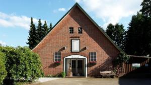 une grande église en briques rouges avec un chien à l'entrée dans l'établissement Haasehof, à Sittensen