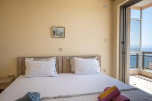 a bedroom with a bed with a large window at Amazing Sea View, Rafina Port, Athens Airport, Self-Check-in in Rafina