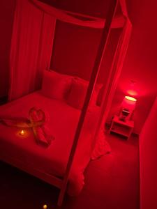 - une chambre dotée d'un lit avec une lumière rouge dans l'établissement Nid’Ange, à Piolenc