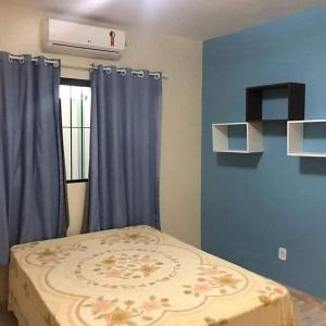 a bedroom with a bed with blue walls and a window at CASA TEMPORADA SÃO JOSE DA COROA GRANDE - PE in São José da Coroa Grande