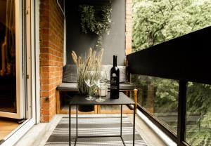 a bottle of wine on a table on a porch at Black Velvet Apartman in Sisak