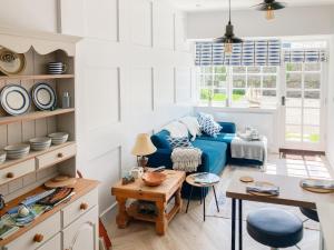Helland的住宿－Keepers Cottage，客厅配有蓝色的沙发和桌子