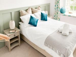 Helland的住宿－Keepers Cottage，一间卧室配有一张带蓝色枕头的大床