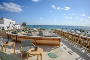 Creta Maris Resort في خيرسونيسوس: فناء مع كراسي وطاولات والمحيط