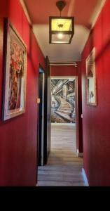 um corredor com paredes vermelhas e um corredor que leva a um quarto em Chez karole proche gare direct Paris em Coulommiers