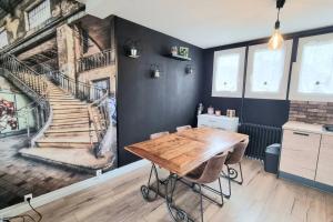 uma sala de jantar com uma mesa de madeira e uma escada em Chez karole proche gare direct Paris em Coulommiers