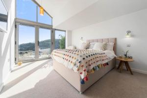 1 dormitorio con cama y ventana grande en The Looking Glass en Dartmouth