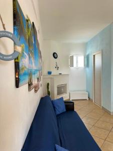a living room with a blue couch and pictures on the wall at Villa Santo Stefano in Monopoli
