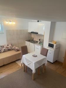 uma pequena sala de estar com uma mesa e uma cozinha em Gallery for two, near the beach and the center of Jelsa em Jelsa