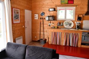 eine Küche mit Holzwänden und ein Sofa in einem Zimmer in der Unterkunft Gîte Etchola in Ramous