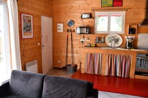 een keuken met houten wanden en een bank in een kamer bij Gîte Etchola in Ramous