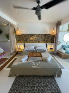 a bedroom with a large bed and a ceiling fan at Love Beach Loft in Marigot