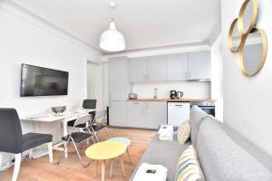 a living room with a couch and a table and a kitchen at Lovely flat 4 P Palais Royal - Musée du Louvre in Paris