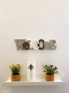 a shelf with two plants and a sign that says love at Casa di Arianna in centro storico a Vimercate in Vimercate