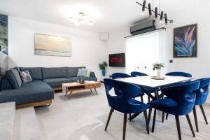 un soggiorno con divano, tavolo e sedie di ILIADA Luxury Apartment a Porto Rafti