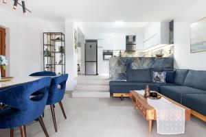 un soggiorno con divani blu e un tavolo di ILIADA Luxury Apartment a Porto Rafti