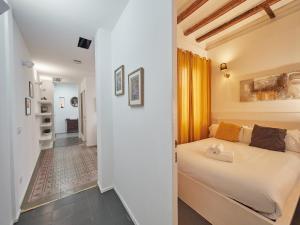 - une chambre avec un lit blanc et un couloir dans l'établissement BarcelonaForRent Alessandra Central Ramblas, à Barcelone