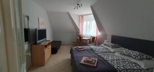 una camera d'albergo con letto e TV di Pihenés Háza-Relax Apartmanhaus a Gyenesdiás