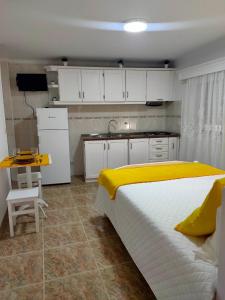 een slaapkamer met een bed en een keuken met witte kasten bij Casa da Sao in Nazaré