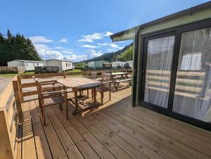 a deck with a table and chairs on it at The Castleton 20 in Ardentinny