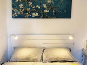 un letto con un dipinto sopra di esso in una camera da letto di Casa di Arianna in centro storico a Vimercate a Vimercate